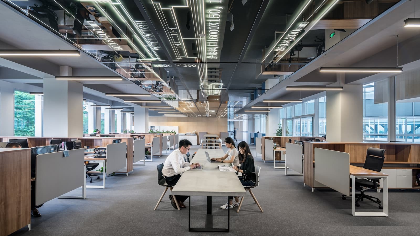 A wide open-plan office floor with two people working