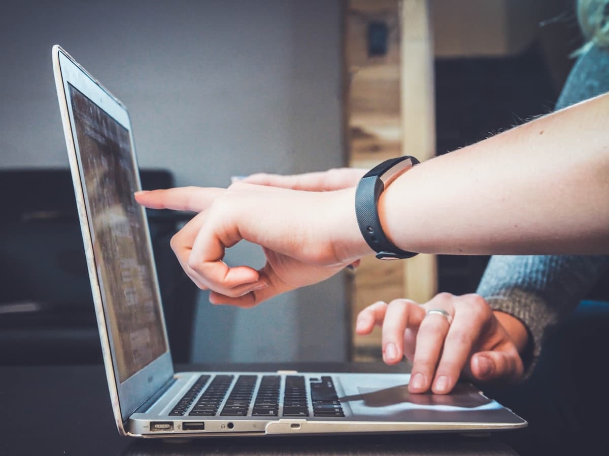 Two people reviewing a page together on a laptop screen