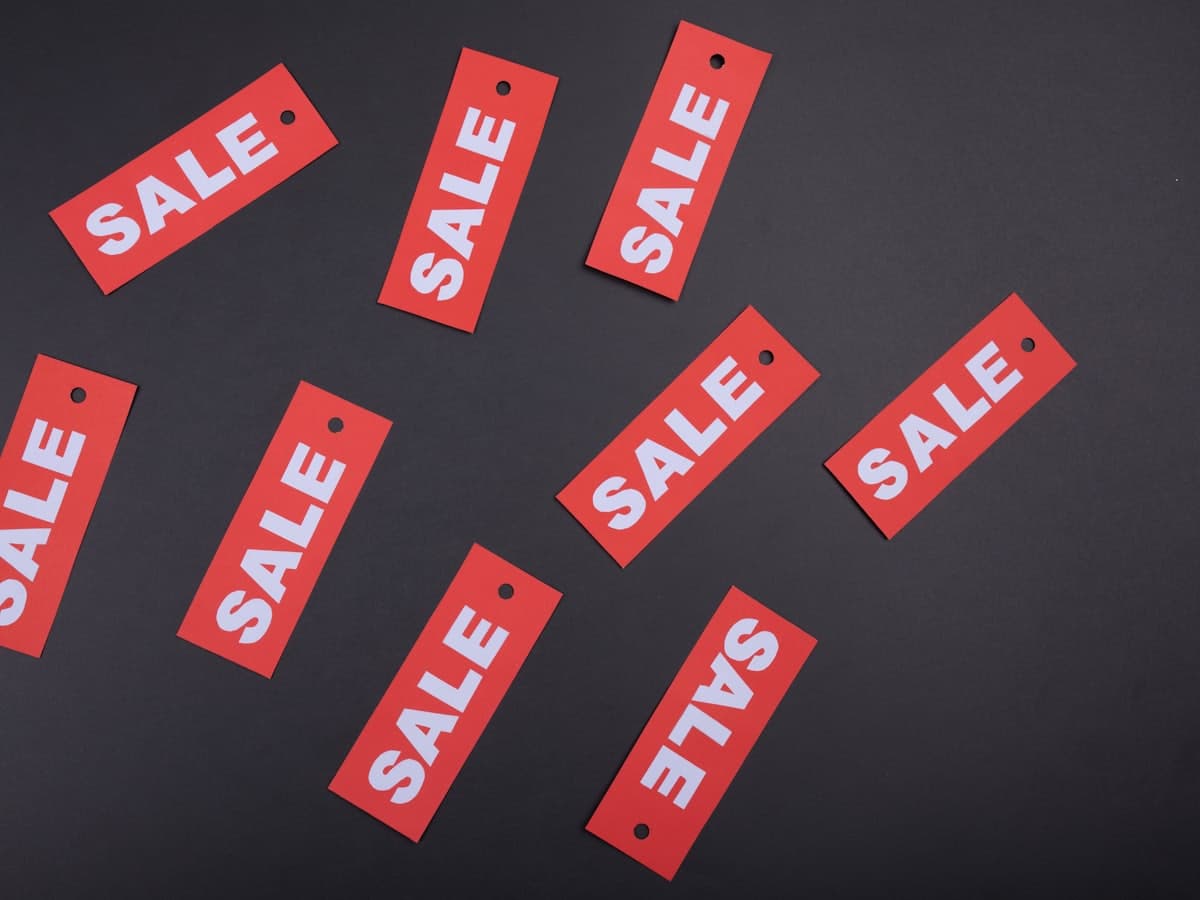 Red retail sale tags arranged on a dark surface